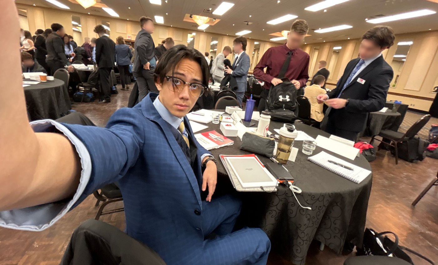 Ethan in a blue suit at a Student Works Painting conference